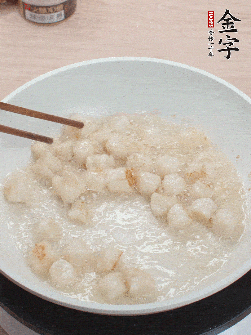 油溫4成熱，鮮貝蘸干淀粉下鍋煎，一面微黃后翻面。