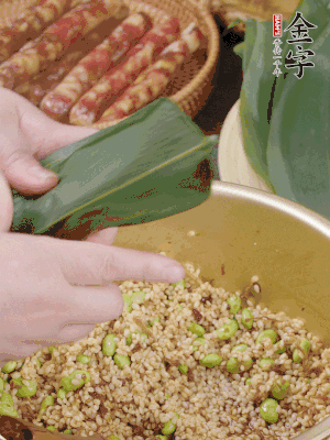 粽葉往下折，完全蓋住，兩側捏緊。